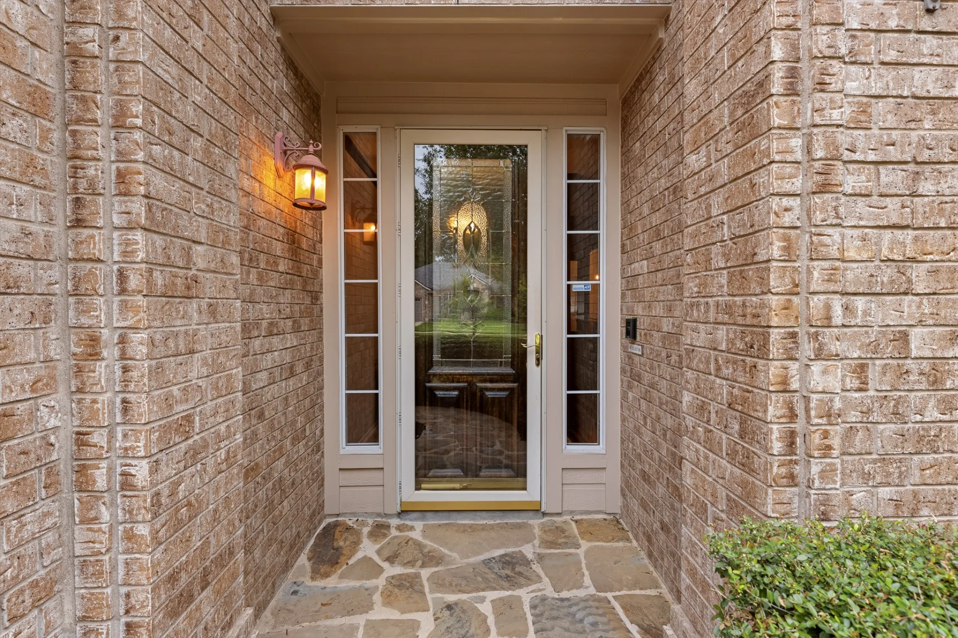 Front door entry with stone walkway and lantern