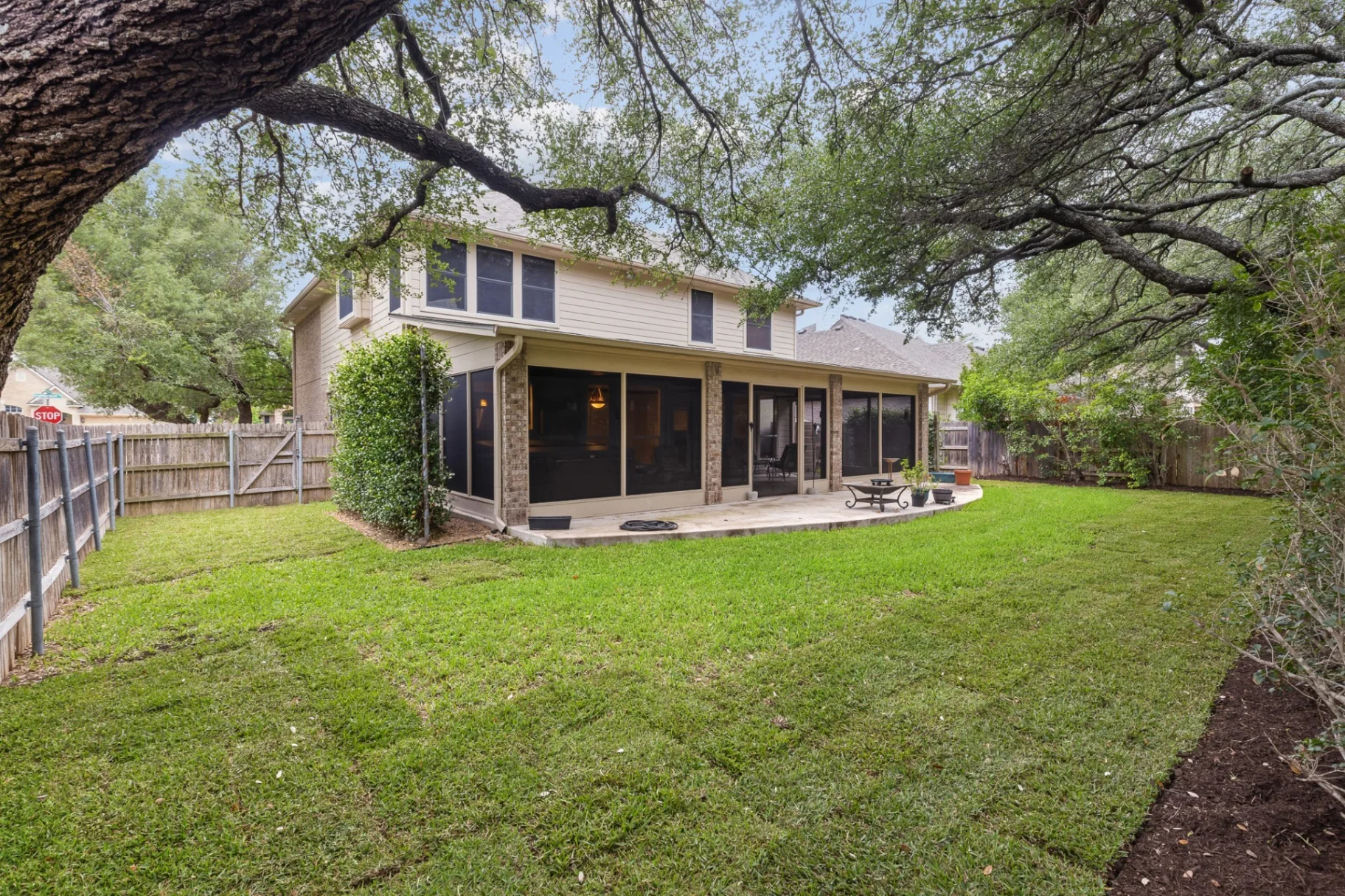 Backyard with mature oaks and screened patio