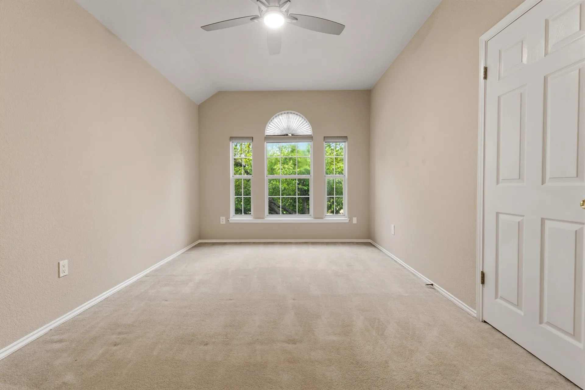 Bedroom with vaulted ceiling and arched picture window